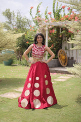 Elegant pink lehenga choli featuring a sleeveless mirror work blouse and a flared skirt with bold golden polka dot motifs.