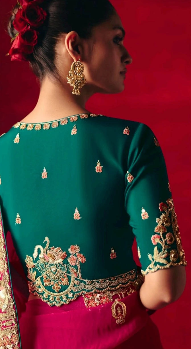 Woman wearing a traditional outfit with intricate embroidery on a red background