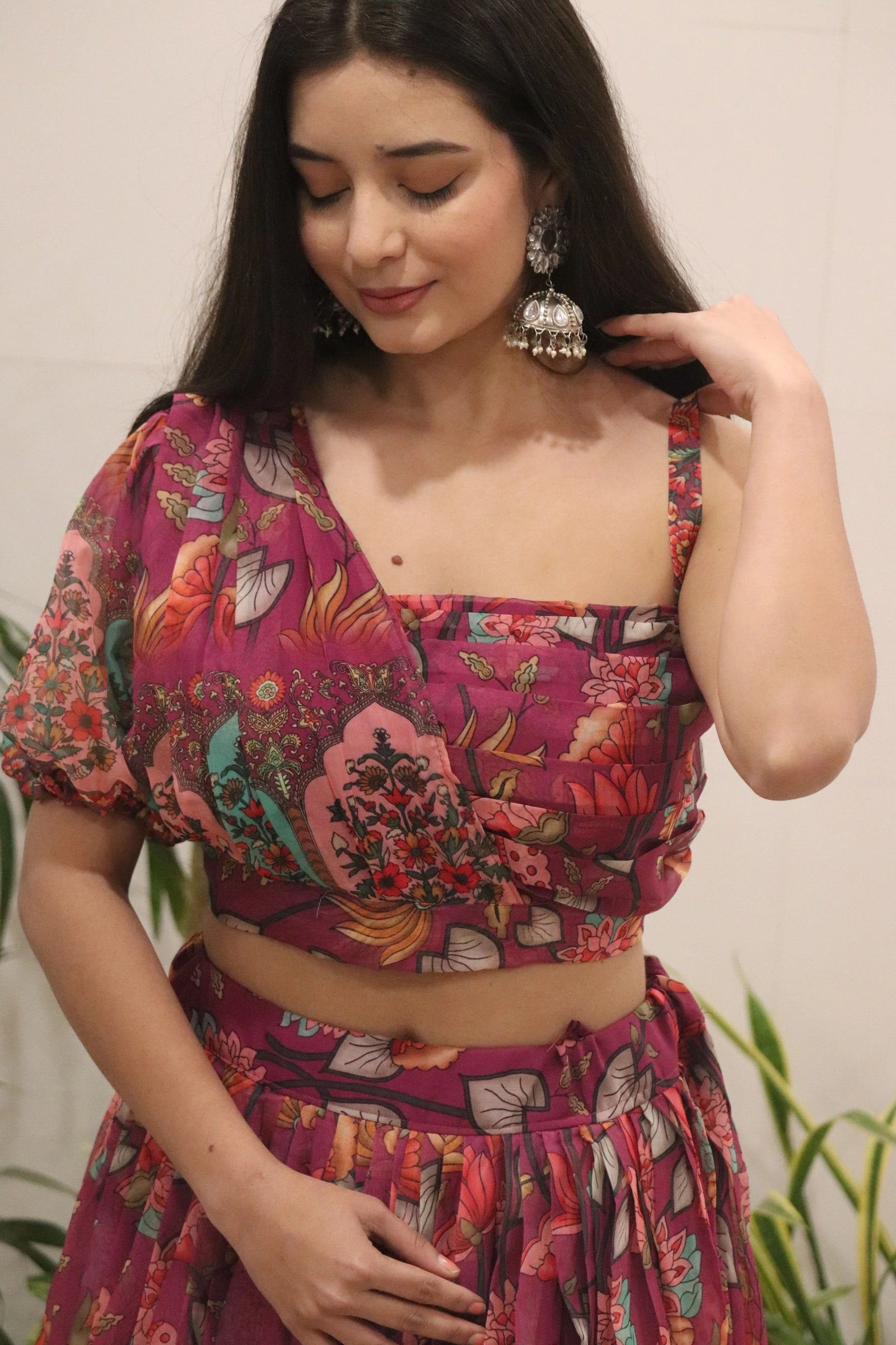 Woman wearing a colorful floral outfit with a plain background