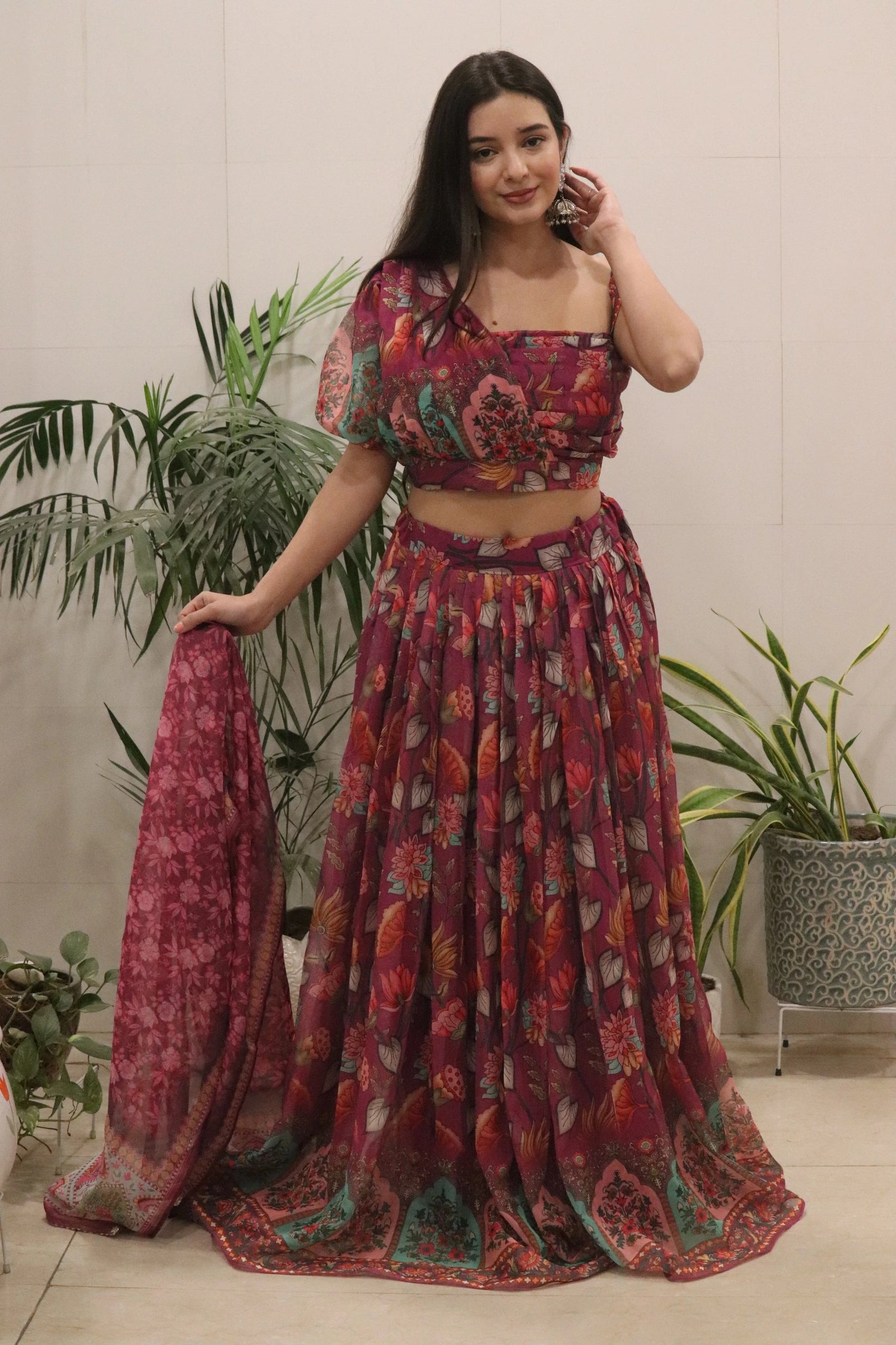 Woman wearing a patterned outfit with plants in the background