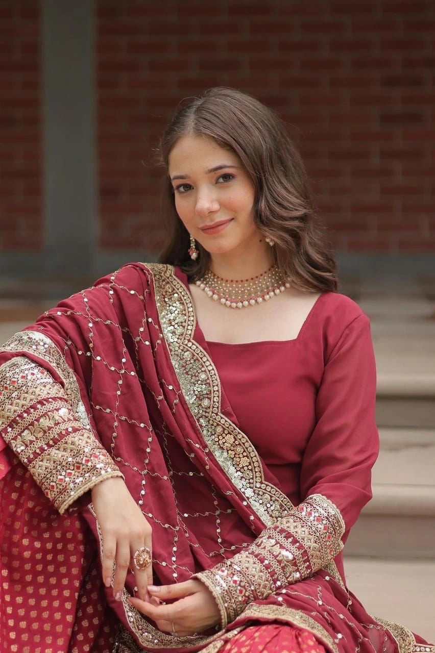 Woman in a red traditional outfit with gold embroidery sitting on steps.
