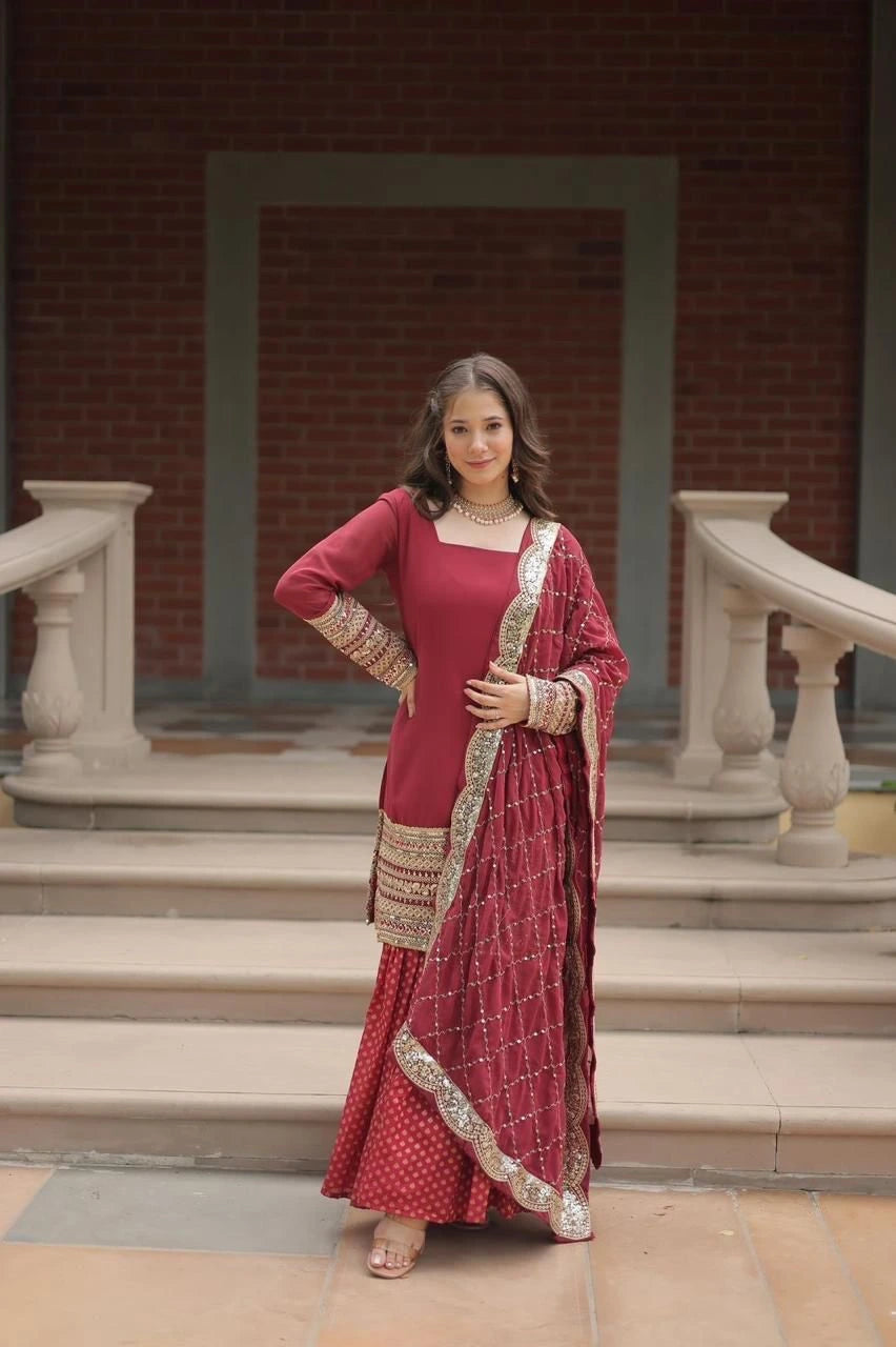 Woman in a red traditional outfit with gold embroidery sitting on steps.