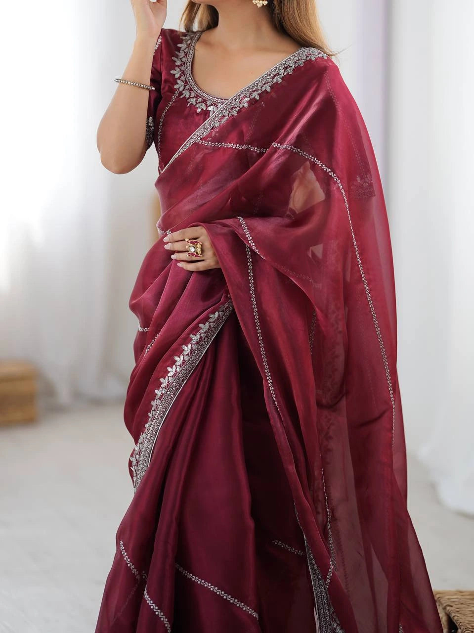 Maroon saree with silver embroidery on a plain background