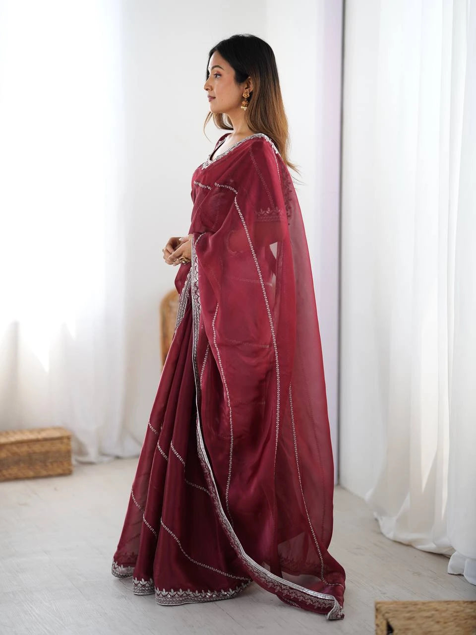 Woman wearing a maroon saree with white border indoors