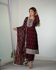 Woman wearing a maroon embroidered outfit with a white background
