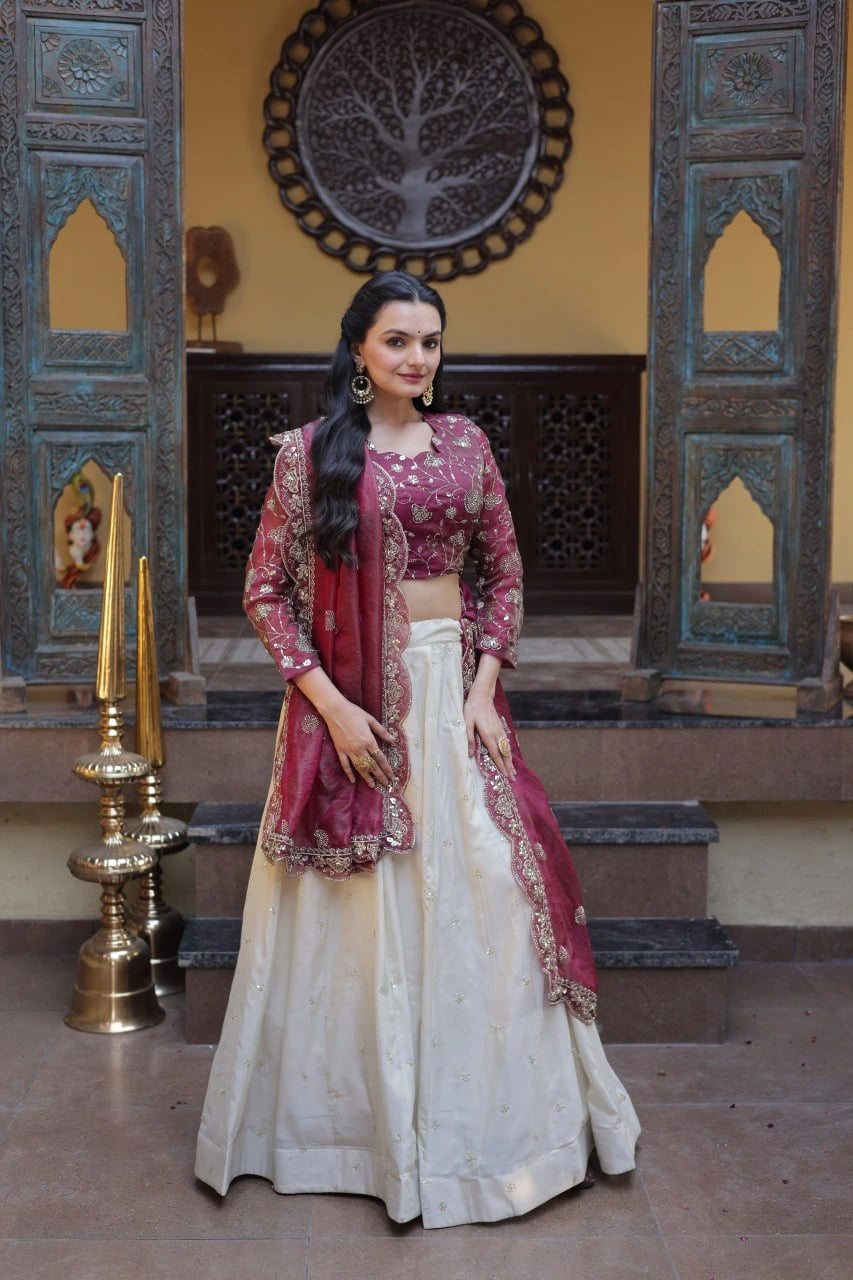 Woman in traditional Indian attire standing in a decorative interior setting.