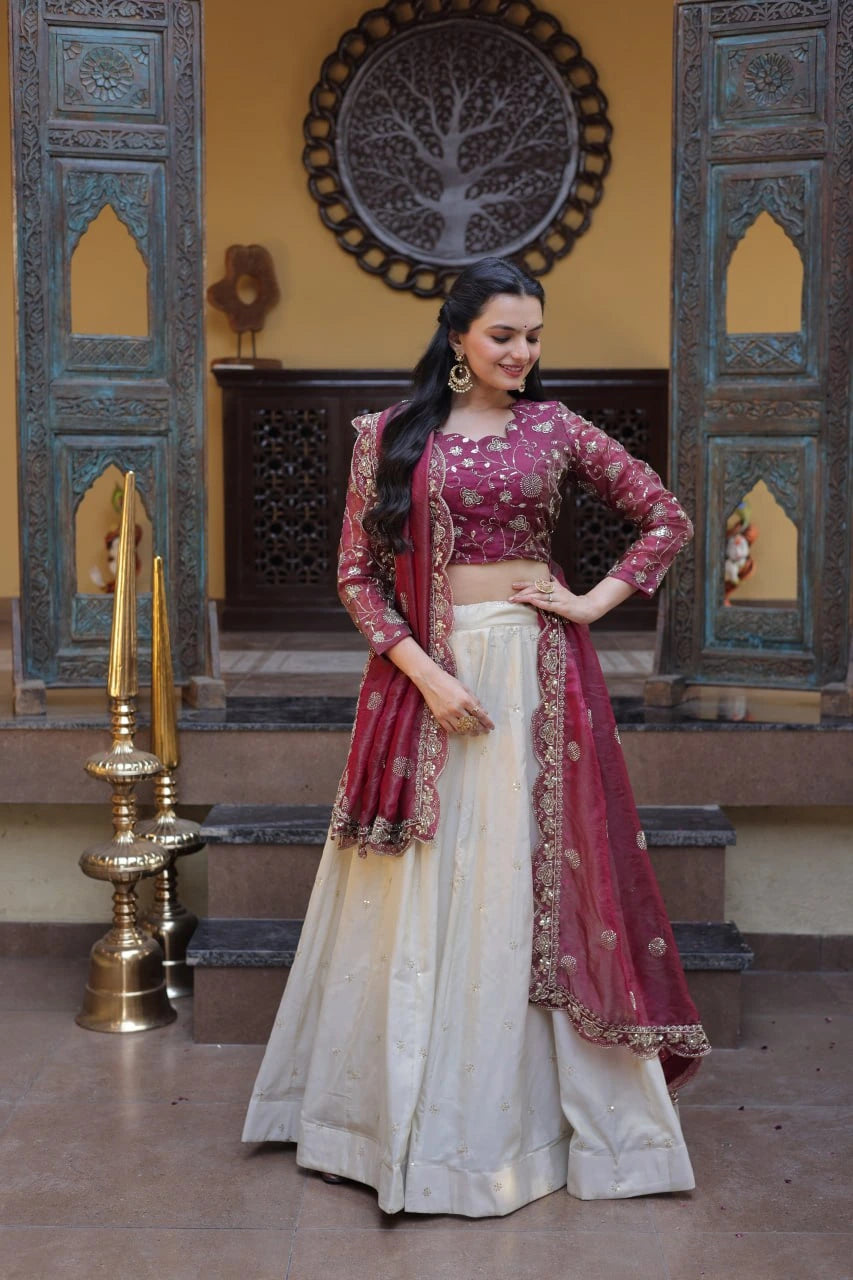 Woman in traditional Indian attire standing in a decorative interior setting.