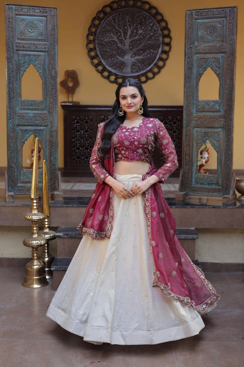 Woman in a traditional pink and white outfit standing in a decorated room.
