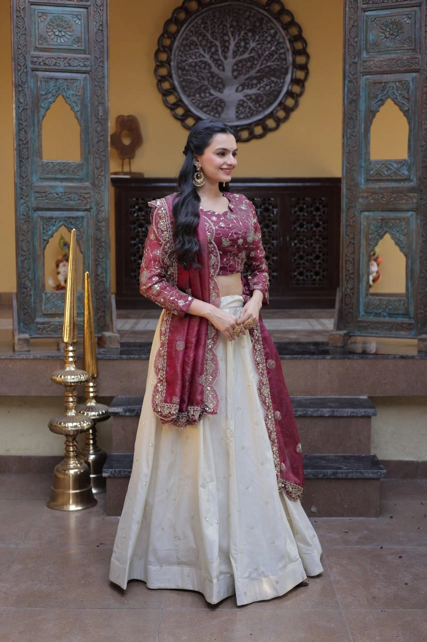 Woman in traditional Indian attire standing in a decorated room with ornate walls and decor.