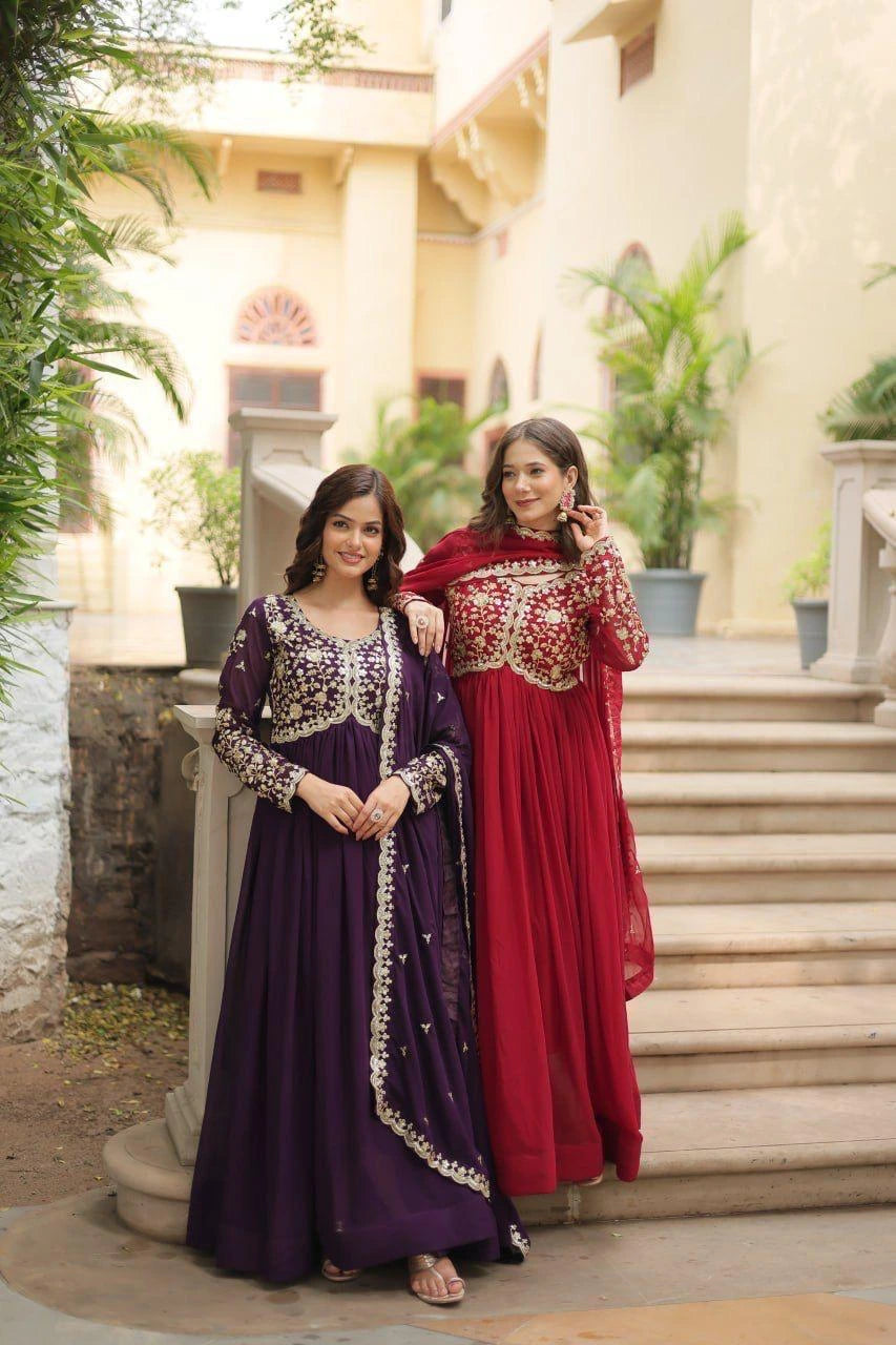 Two women in traditional outfits standing on steps outdoors.