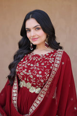 Woman wearing a red embroidered traditional outfit against a beige background