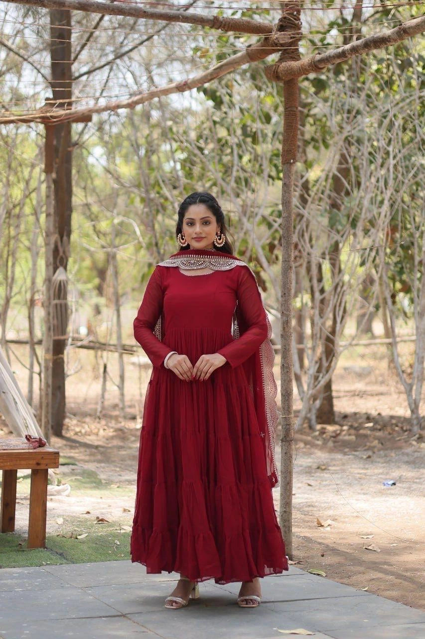 Woman in a red dress standing outdoors with trees in the background