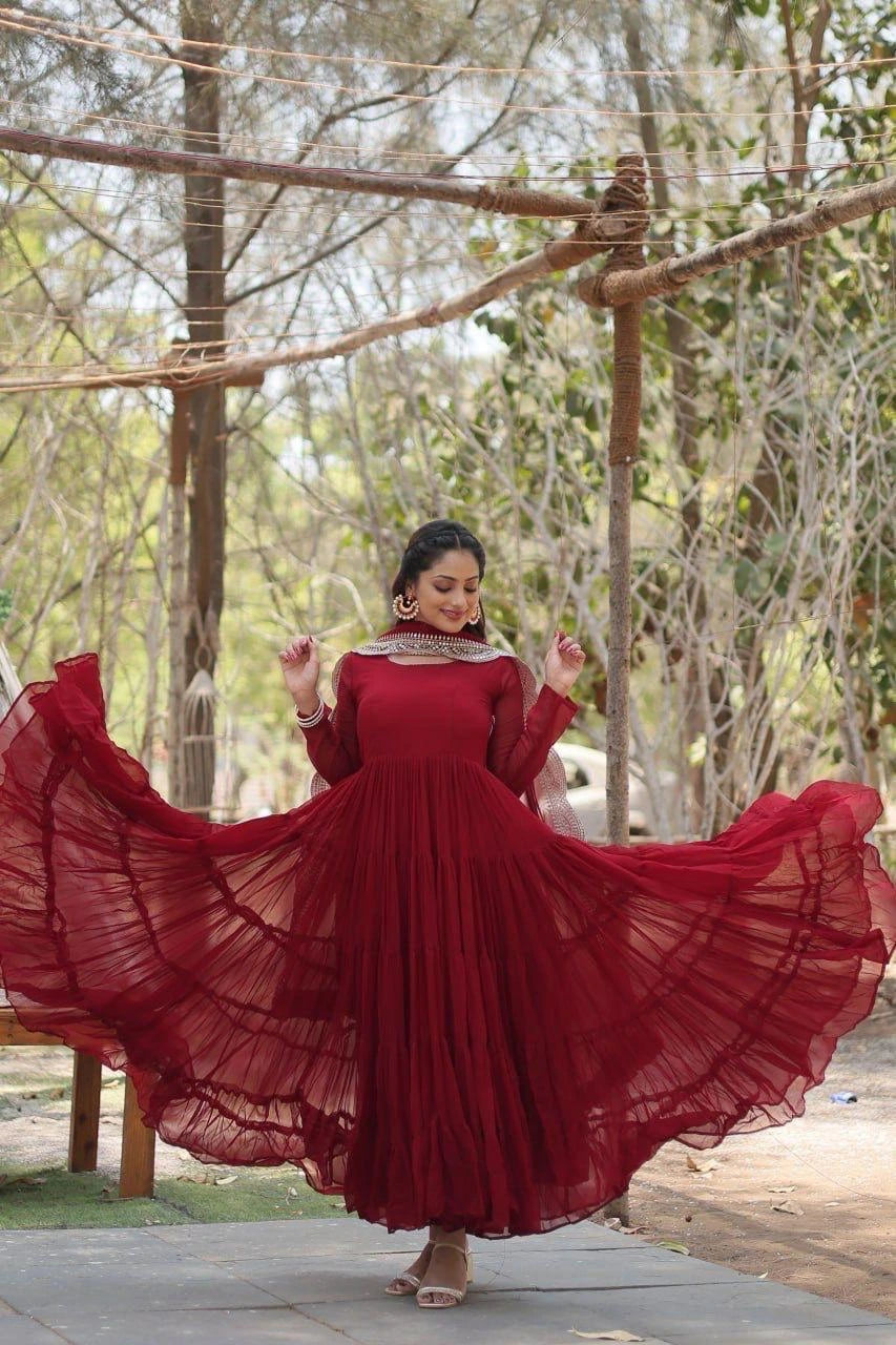 Woman in a red dress standing outdoors with trees in the background