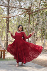 Woman in a red dress dancing outdoors with trees in the background