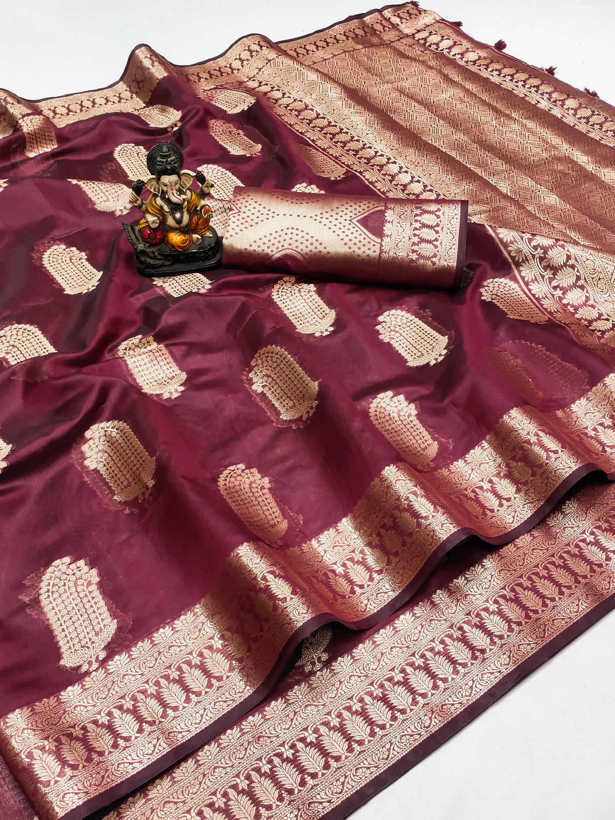 Maroon saree with gold patterns on a white background