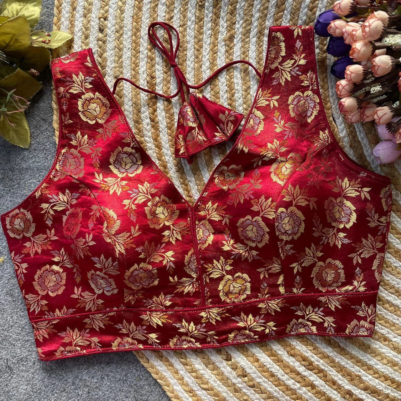 Red floral-patterned top on a textured surface with decorative elements.