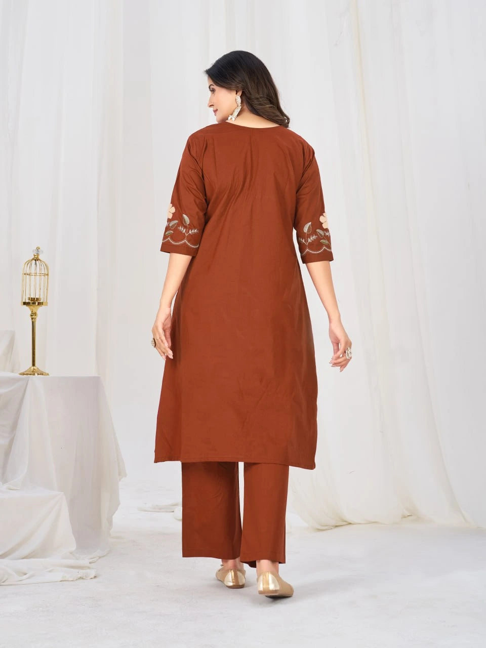 Woman wearing a brown kurta with matching pants against a white background