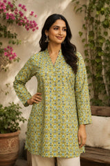 Woman wearing a green floral patterned kurta with plants and flowers in the background