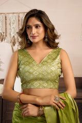 Woman wearing a green traditional outfit with a patterned top and saree.