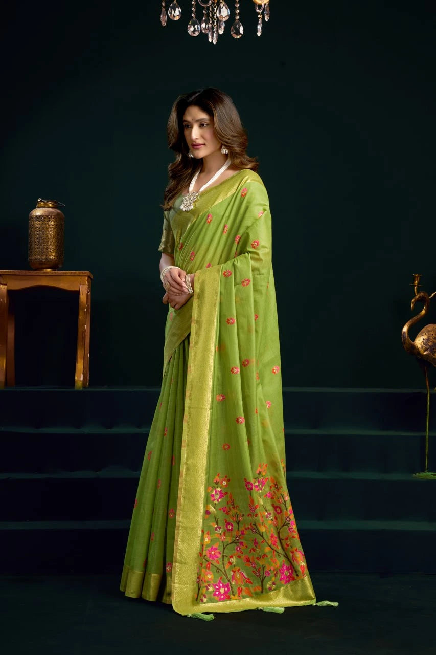 Woman wearing a green saree with floral patterns on a dark background