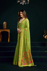 Woman wearing a green saree with floral patterns on a dark background