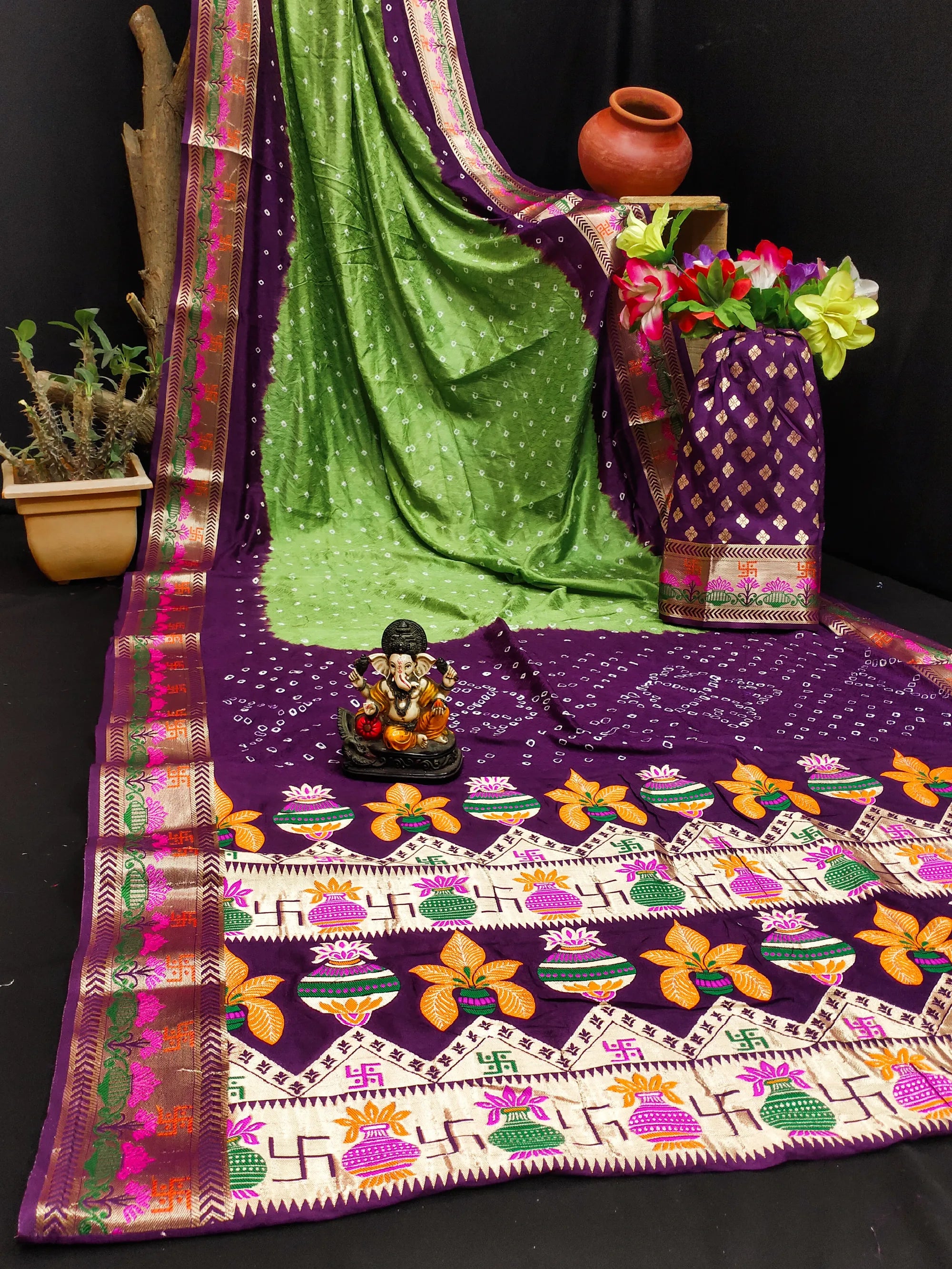 Decorative tablecloth with floral patterns and a green saree draped over it.