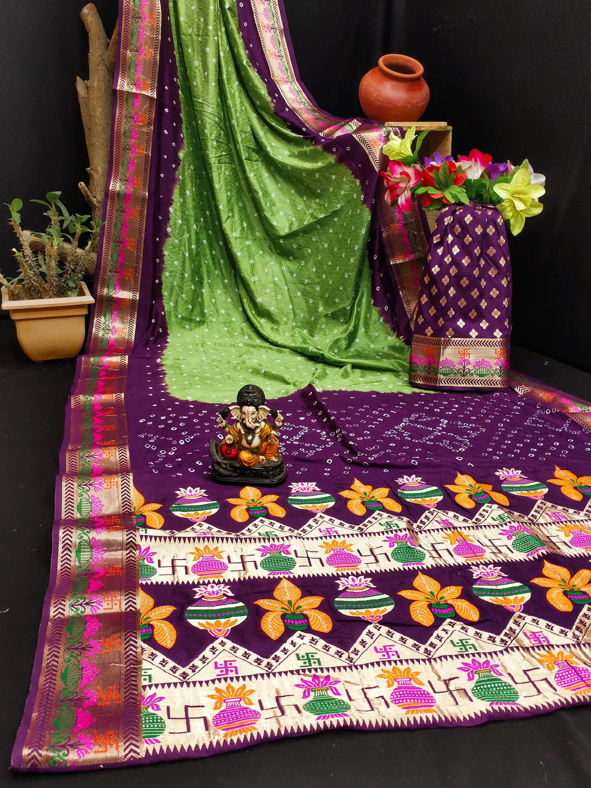 Decorative tablecloth with floral patterns and a green saree draped over it.