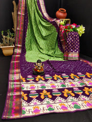 Decorative tablecloth with floral patterns and a green saree draped over it.