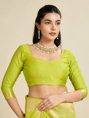 Woman wearing a green traditional outfit with jewelry on a beige background