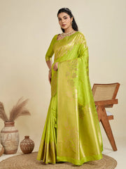 Woman wearing a green saree with a gold border on a beige background