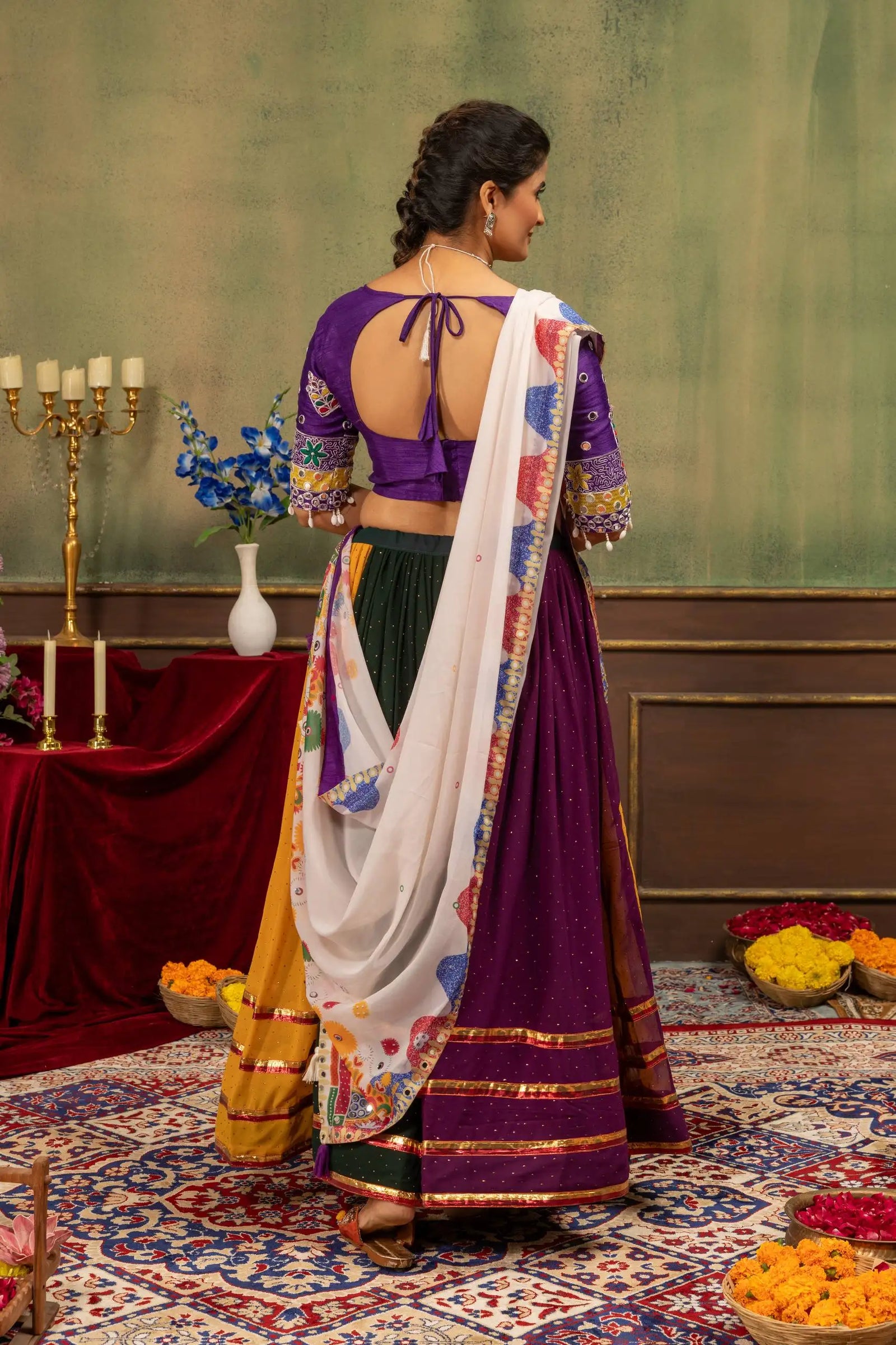 Back view of multicolor lehenga showing U-back tie-up choli and Kutchi printed dupatta draped