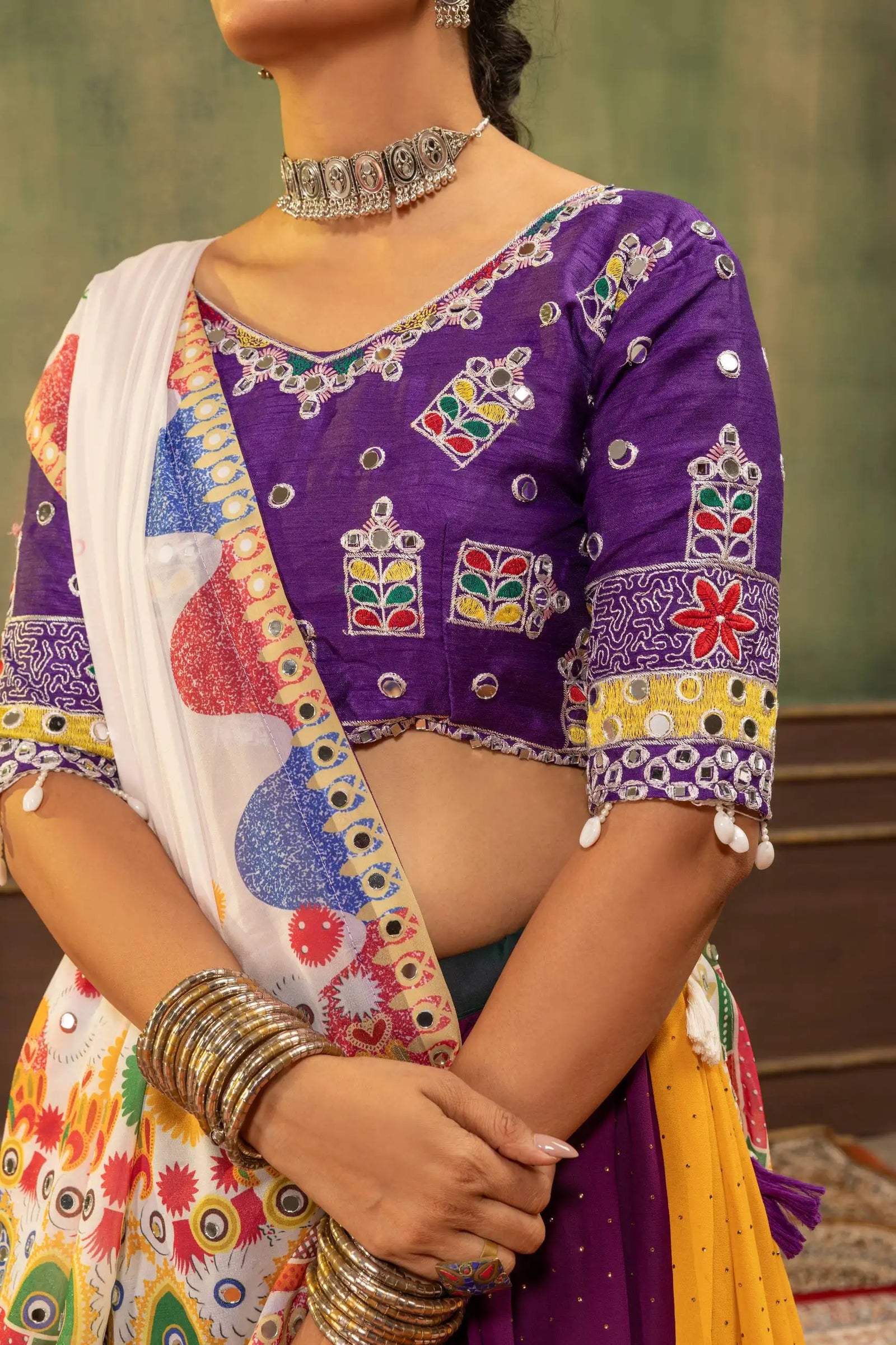 Close-up of purple Gamthi embroidered choli with mirror work, V-neck and colorful floral motifs