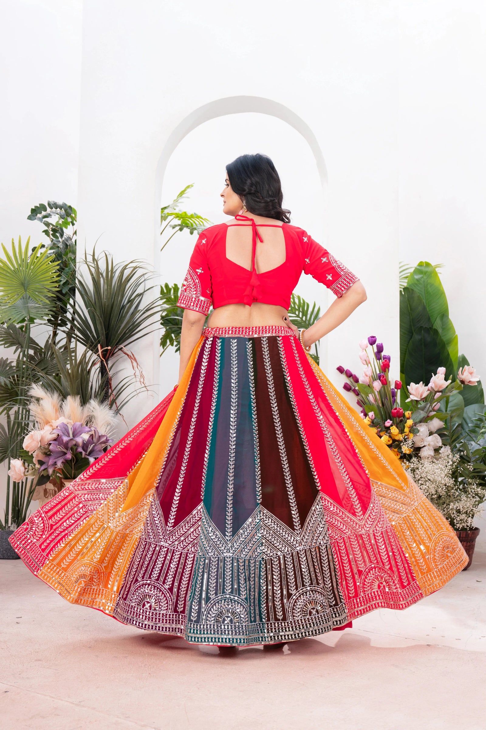 Back view of multicolor lehenga showing U-back choli with dori tie-up and twirling circular skirt