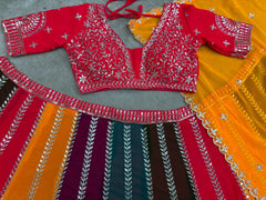 Flat lay of multicolor lehenga set showing red embroidered choli and orange dupatta with sequins border