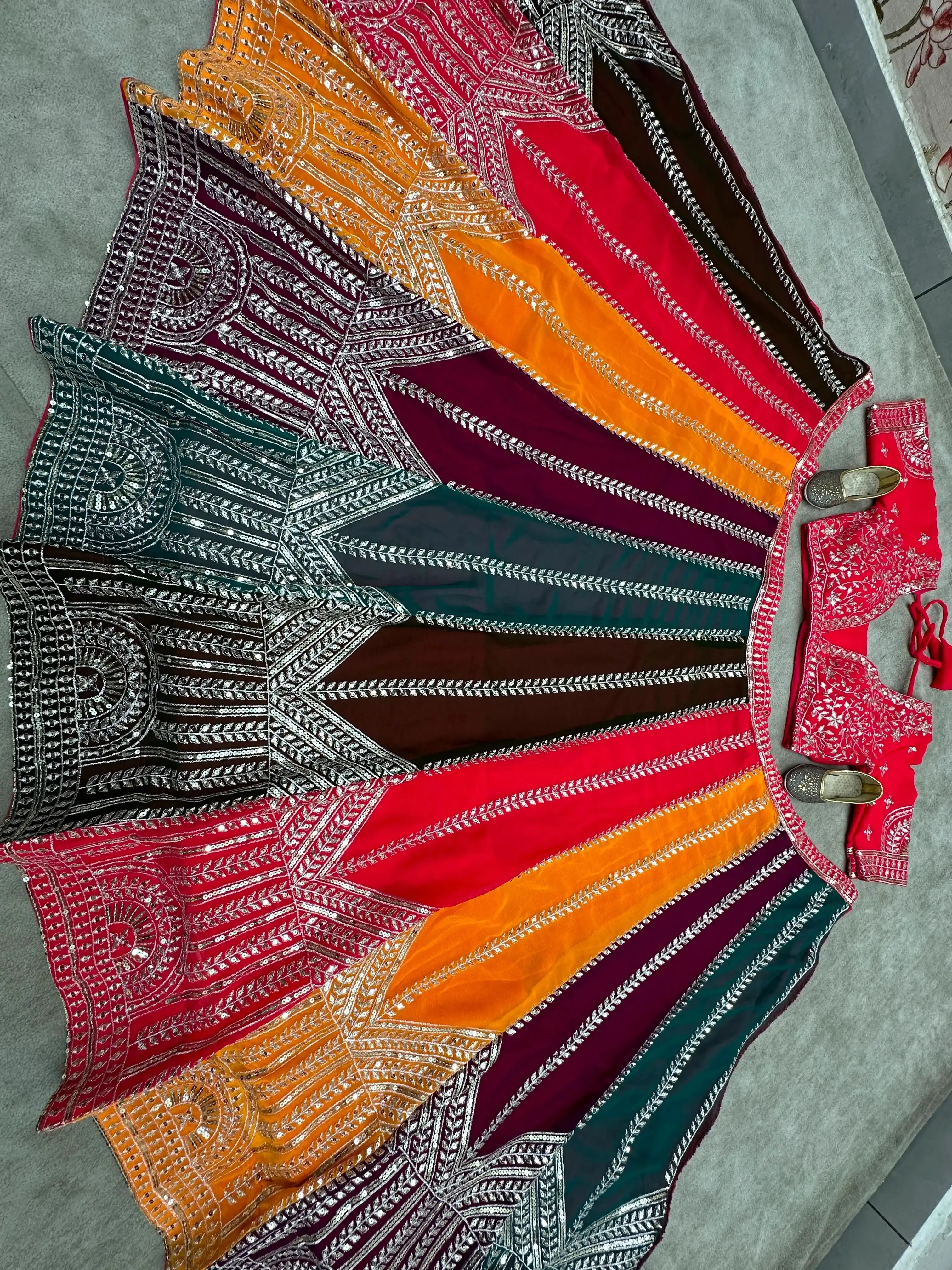 Top-down flat lay of 4-meter flair multicolor circular lehenga with full sequins and zari embroidery