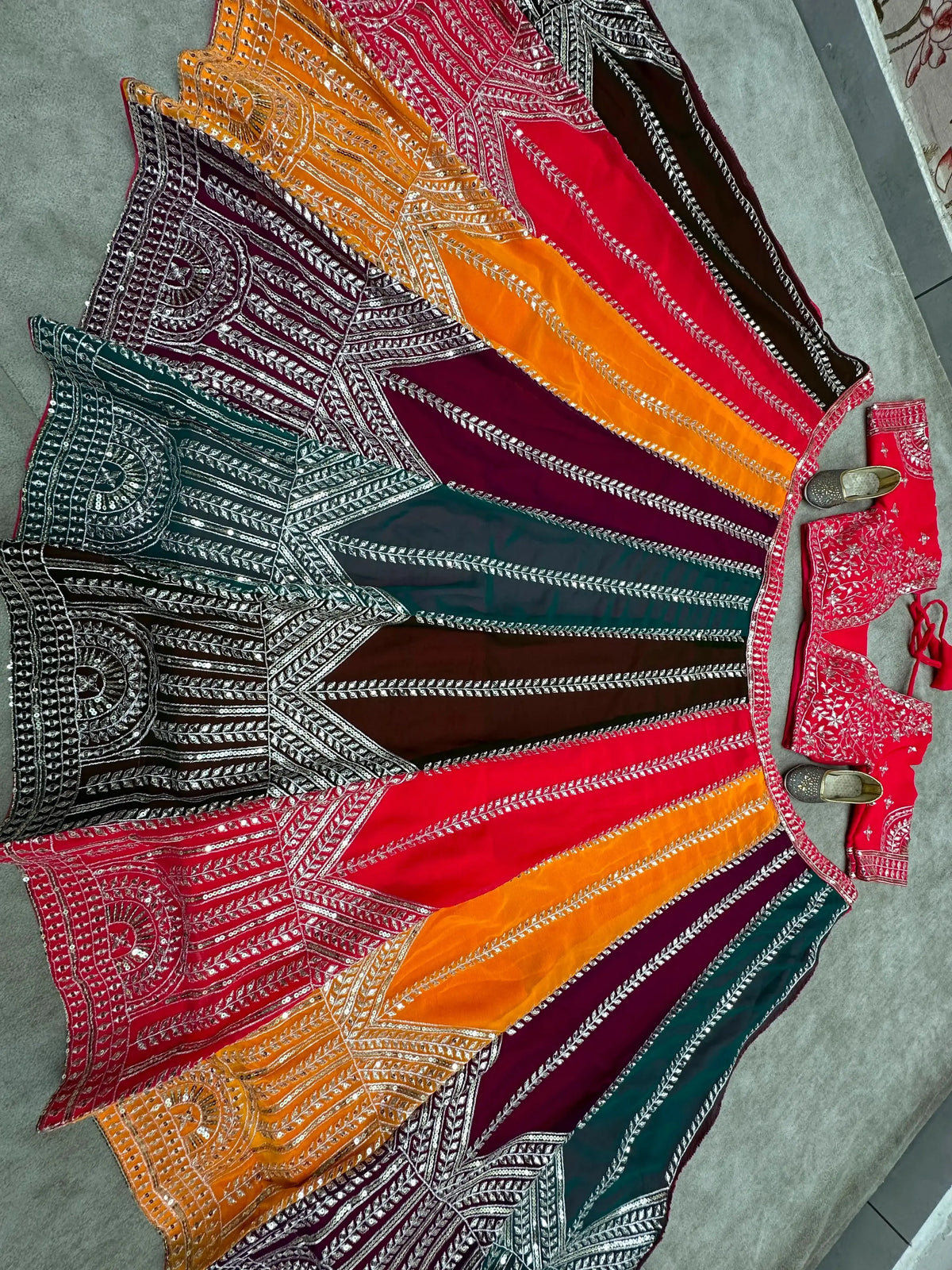 Top-down flat lay of 4-meter flair multicolor circular lehenga with full sequins and zari embroidery