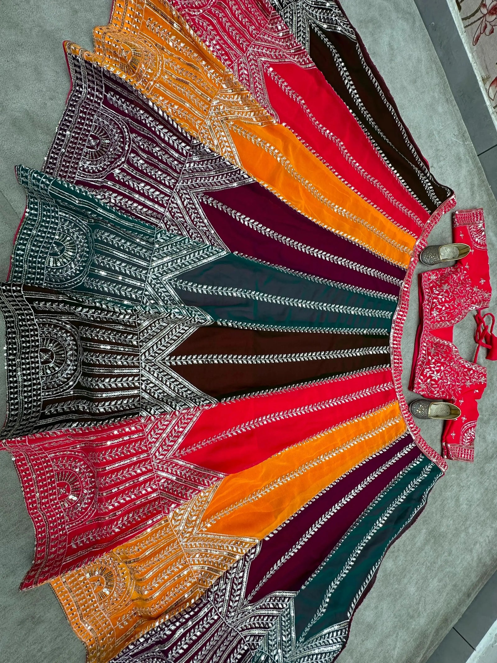 Top-down flat lay of 4-meter flair multicolor circular lehenga with full sequins and zari embroidery