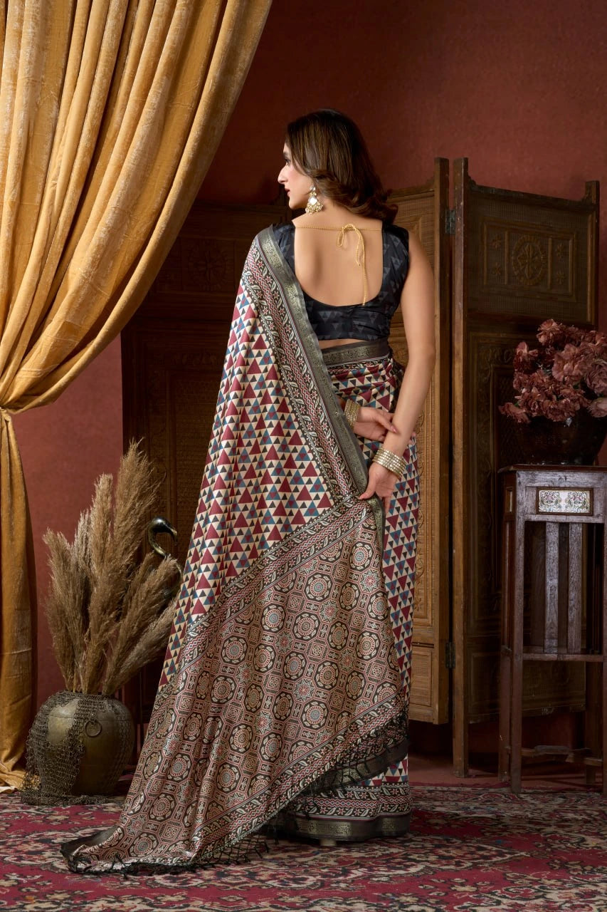 Woman in a patterned saree standing in a room with decorative elements.