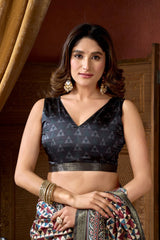 Woman wearing a black patterned top and colorful skirt indoors.