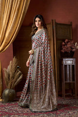 Woman in a patterned dress standing in a room with decorative elements.