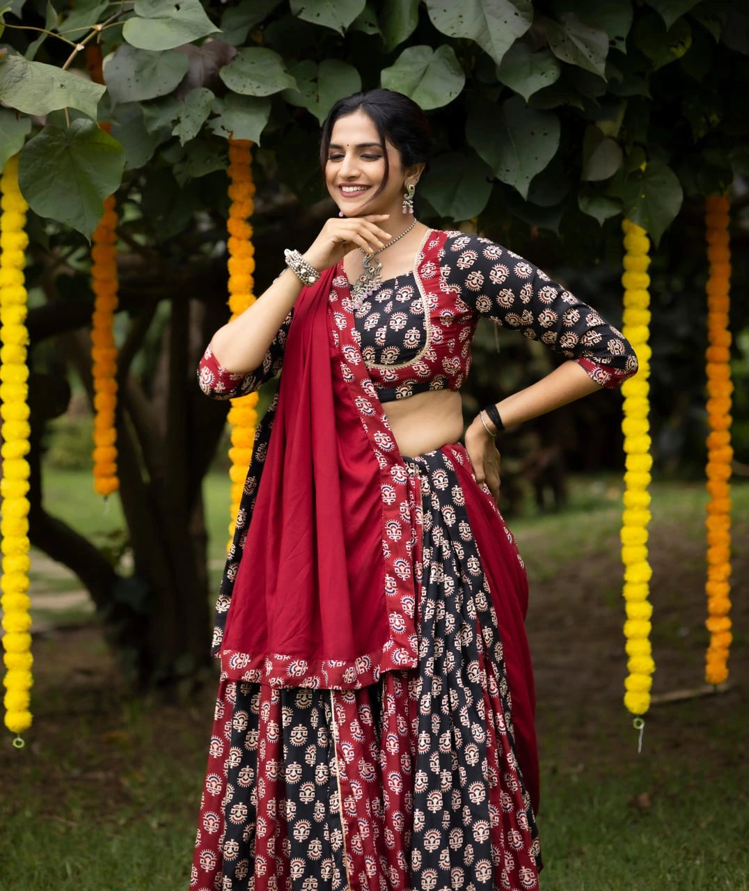 Woman in a traditional outfit standing outdoors with decorative elements in the background