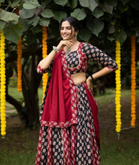 Woman in a traditional outfit standing outdoors with decorative elements in the background