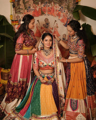 Three women in traditional Indian attire with a colorful background