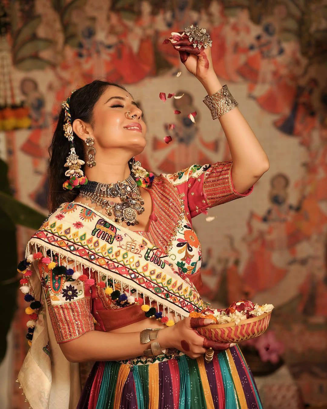 Woman in traditional attire with jewelry and a colorful background