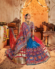 Woman in a colorful traditional outfit standing in an ornate room.