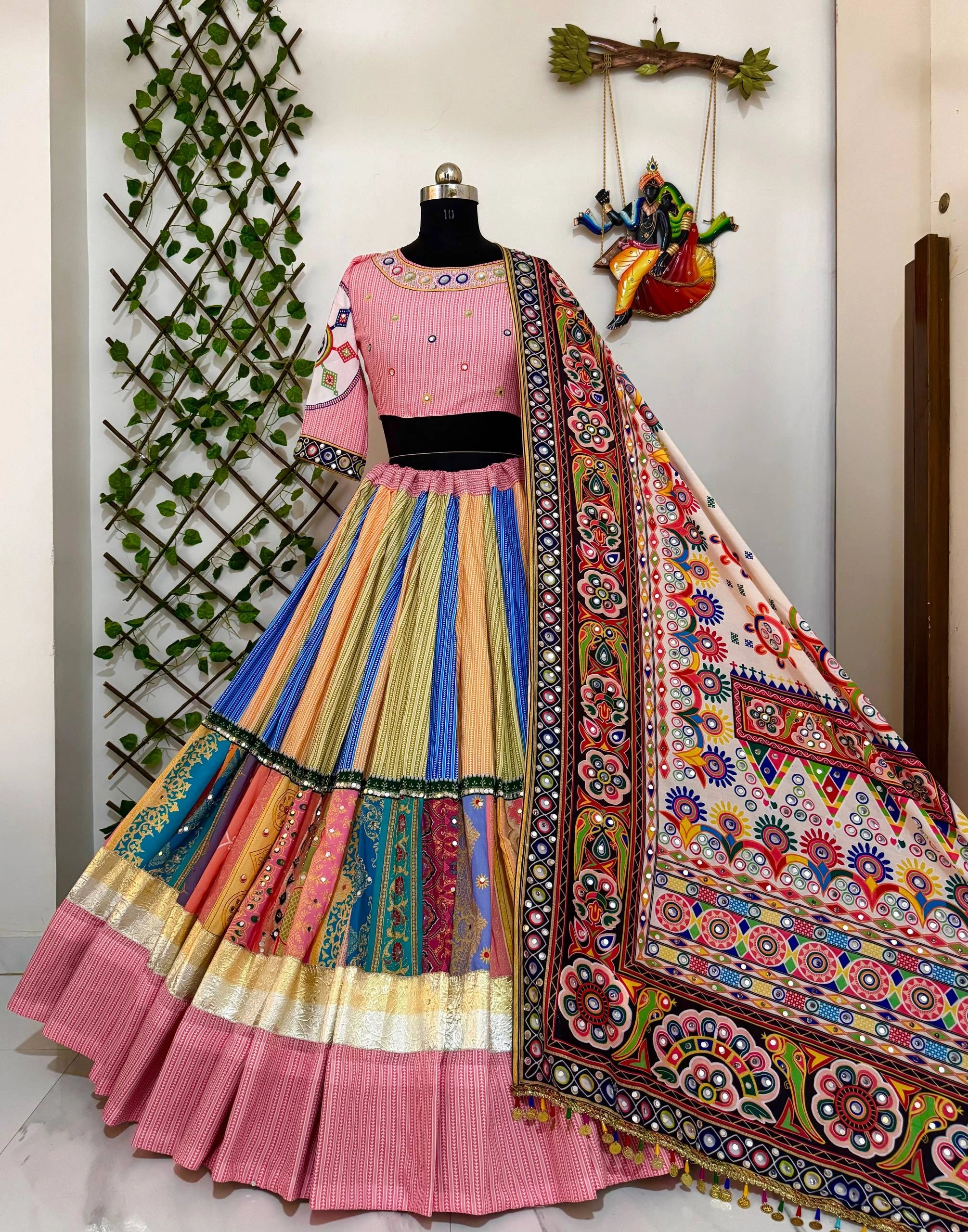 Colorful traditional outfit with a mannequin against a decorative wall.
