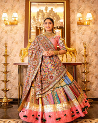 Woman in traditional multicolored outfit with intricate patterns in a decorated room.
