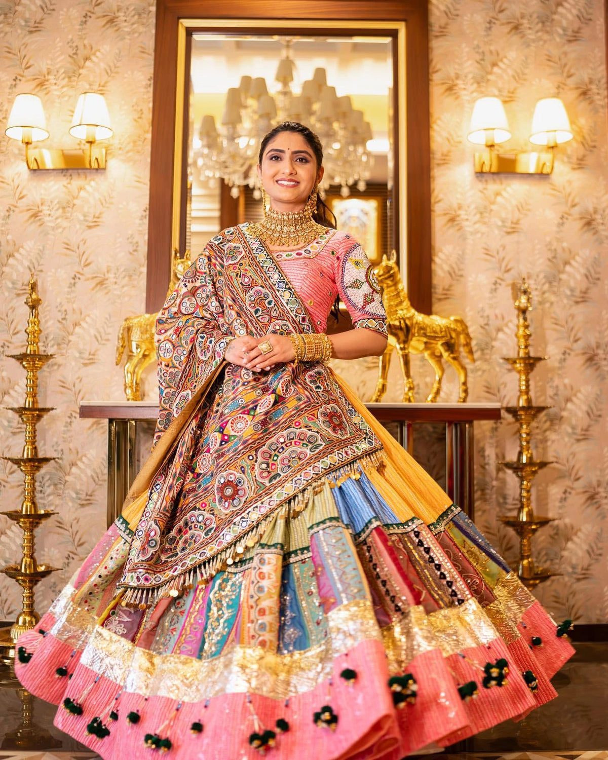 Woman in traditional multicolored outfit with intricate patterns in a decorated room.