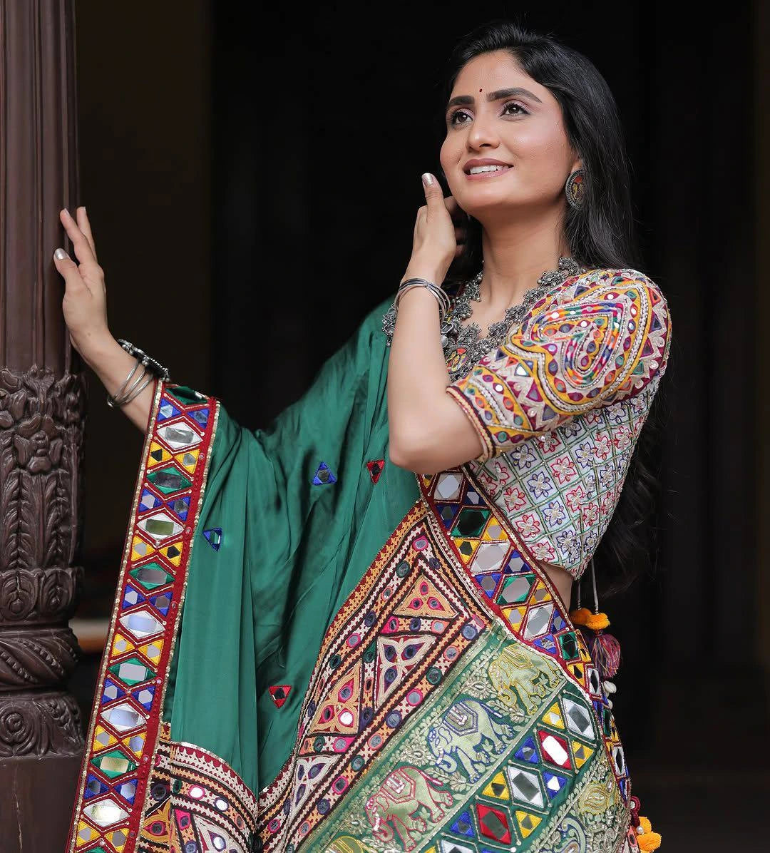 Woman wearing a colorful traditional outfit with a green background
