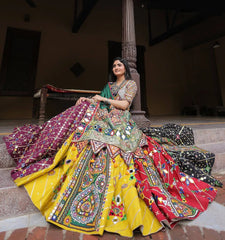 Woman in a colorful traditional outfit sitting on steps.